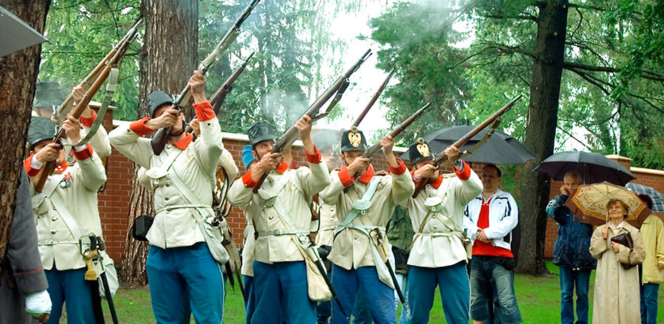 Vojáci v historických uniformách pálící čestnou salvu.