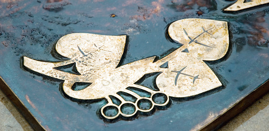 Symbol lipových listů na bronzovém náhrobku.